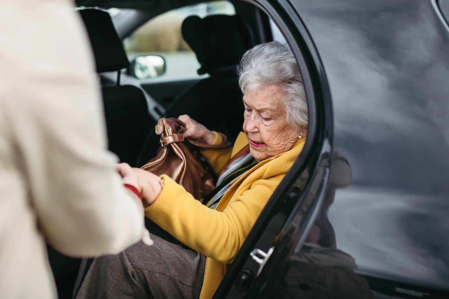 senior being assisted into a vehicle Image